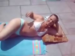 In a homemade video, a redhead hussy in a bikini displays her physique.